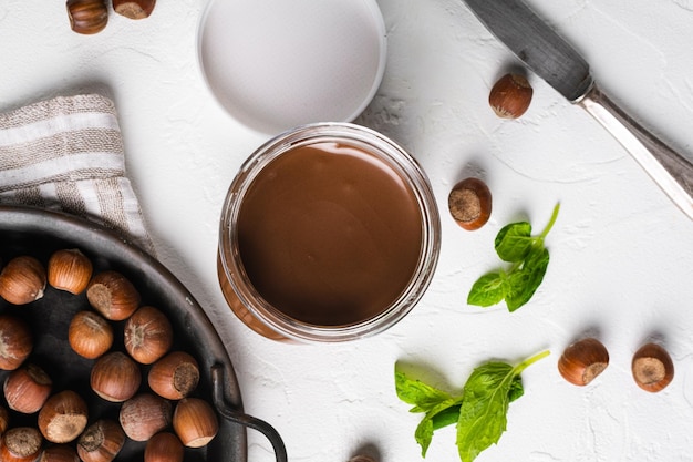 Crema de chocolate para untar o turrón con avellana sobre fondo de mesa de piedra blanca vista superior plana