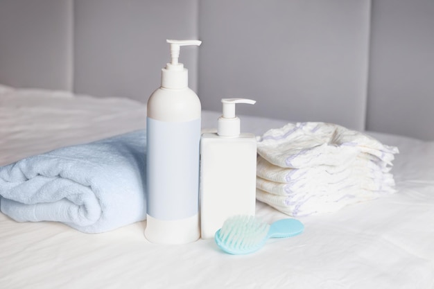 Crema corporal peine toalla de baño pañales desechables y pañales en una cama Cuidado del bebé Primeros días de vida Alimentación y maternidad