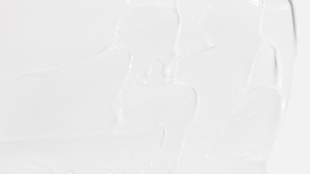 Crema cosmética blanca manchada sobre un fondo blanco