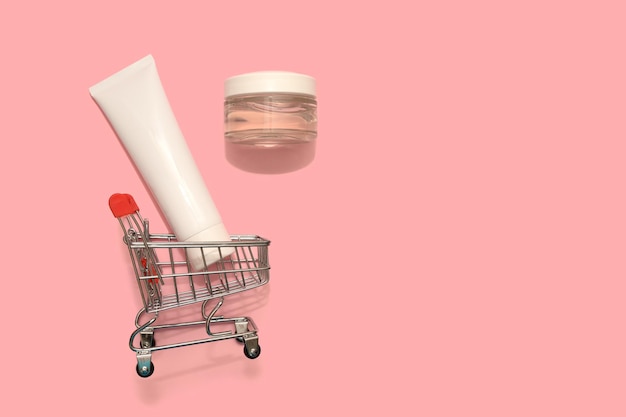 Crema cosmética blanca en mini cesto. Sobre un fondo rosa. Tienda de Internet para el hogar.