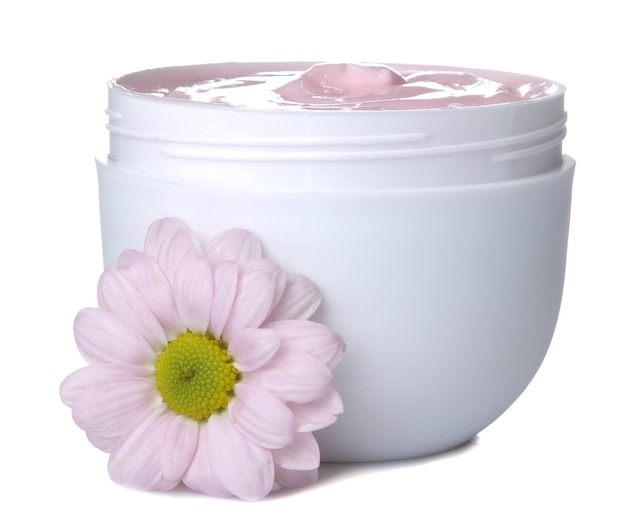 Crema cosmética para rostro y cuerpo Crema rosa y flor en un frasco blanco sobre un fondo blanco aislado