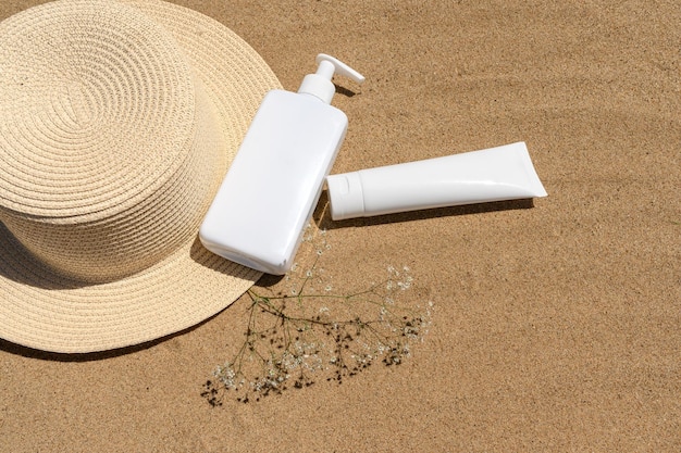Crema cosmética en un sombrero de paja en la arena Cuidado de la piel