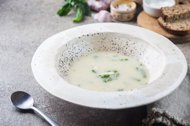 Crema de espárragos frescos en un recipiente sobre la mesa de piedra gris