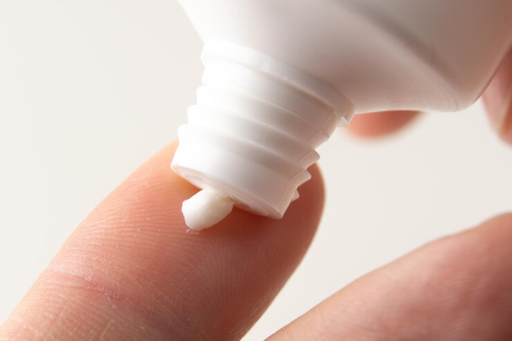 Foto la crema se exprime en el dedo de un hombre de un tubo blanco usando crema de manos