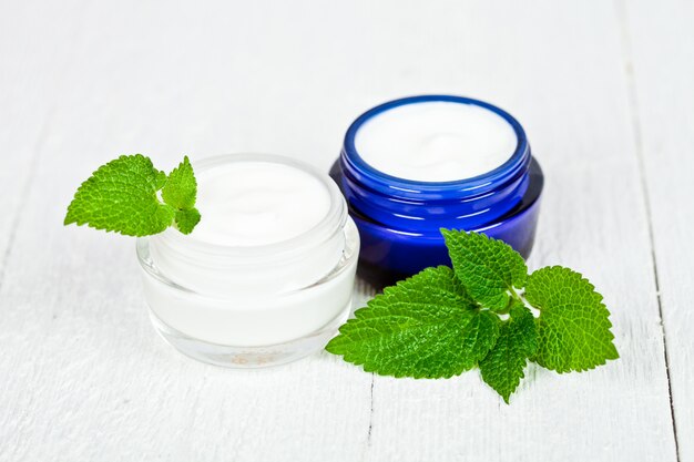 Crema facial en frascos con hojas de urtica.