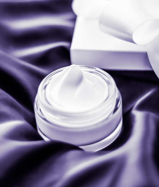 Crema facial hidratante de lujo con aroma a lavanda sobre belleza para el cuidado de la piel de seda violeta