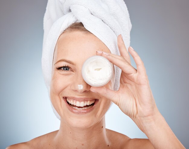 Foto crema facial o para el cuidado de la piel de la mujer en el cuidado de la salud de rutina o tratamiento de colágeno en el fondo gris del estudio retrato sonrisa feliz o modelo de belleza o producto para el cuidado de los ojos en dermatología de canadá