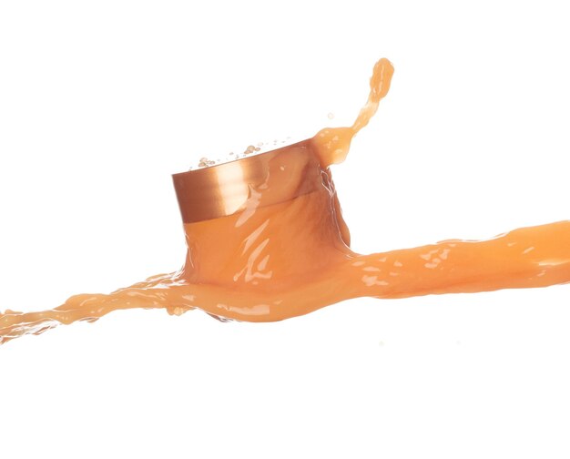 Crema de loción hidratante de jugo de naranja que se vierte en un recipiente de botella de cosméticos Loción de belleza de pintura naranja volando explosión en el aire salpicaduras derramar como gotas de explosión Fondo blanco aislado