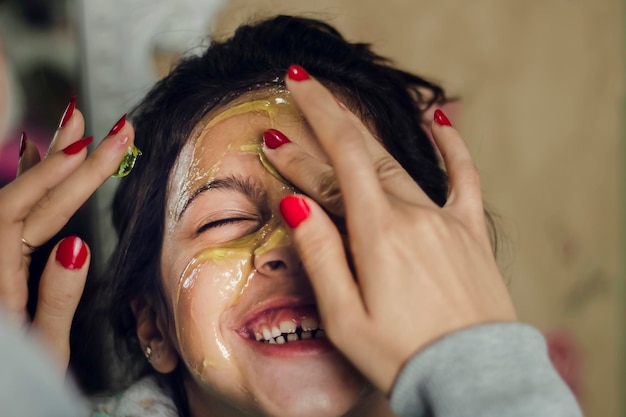 Crema de masaje para la carita de una niña riendo.