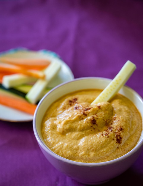 Foto crema de pimientos rojos asados y verduras crudas