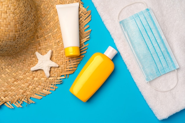 Crema de protección solar y mascarilla protectora. Concepto de verano de coronavirus