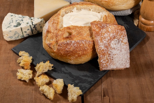 Foto crema de queso dentro de pan italiano con picatostes, fondue.