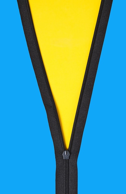Cremallera desabrochada con fondo azul amarillo con espacio para copiar
