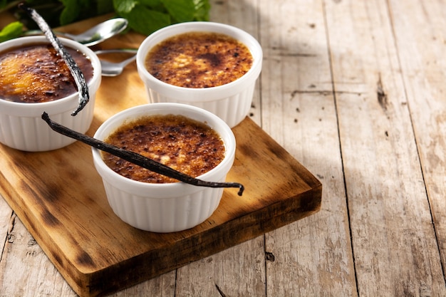 Foto creme brulee caseiro em uma tigela na mesa de madeira