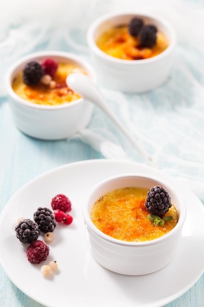 Foto creme brulee decorado com amora em um prato branco