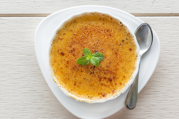 creme brulee em tigela guarnecido com folhas de hortelã