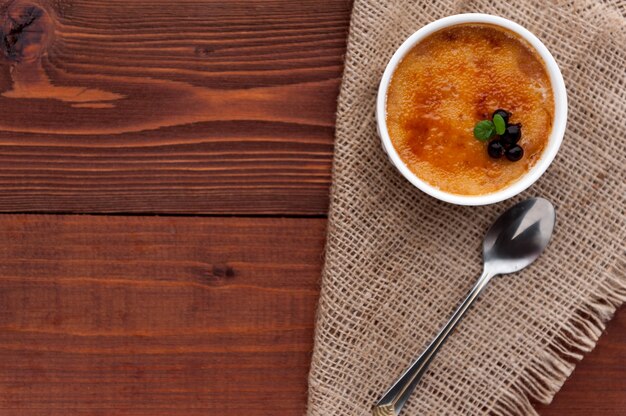 Creme brulee em uma tigela branca com crosta de açúcar. Fotografia de estúdio. estilo sertanejo.