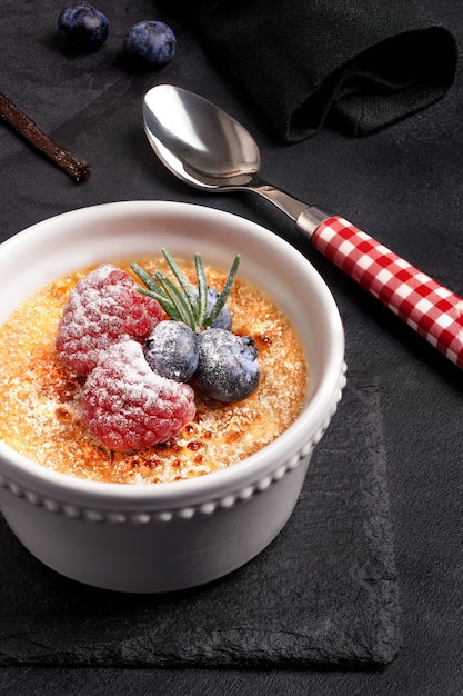 Creme Brulee mit Beeren auf dunklem Stein