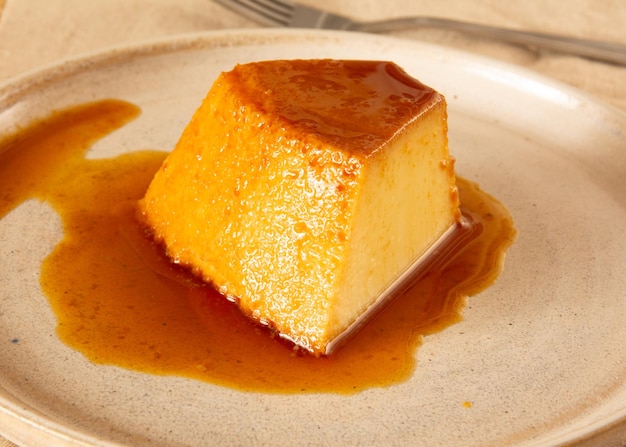 Creme Caramel Kondensmilch Pudim-Scheibe vorne mit beige Hintergrund