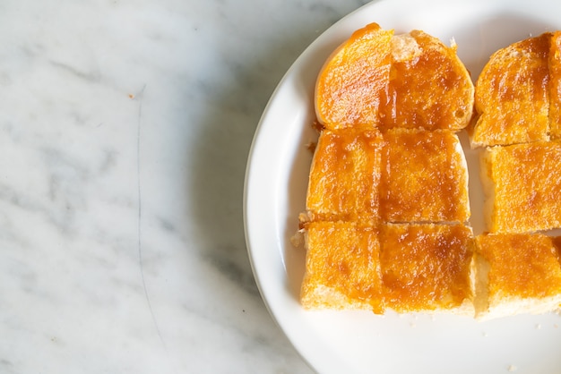 Creme com pão torrado em prato branco