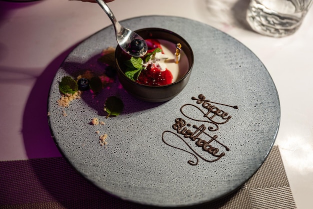 Creme de baunilha com bolo de frutas na placa de cerâmica de feliz aniversário