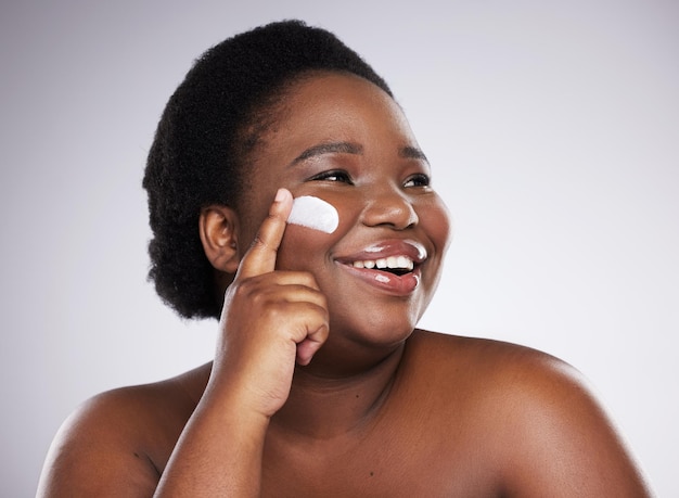 Creme de beleza e mulher negra isolada em um fundo branco para produtos para a pele ou aplicar cosméticos Modelo africano ou rosto de pessoa com hidratante de colágeno e ideia de dermatologia em maquete de estúdio