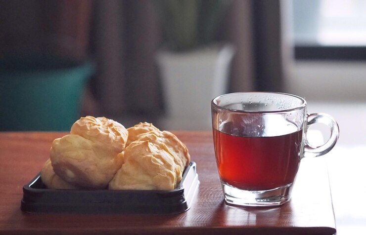 Foto creme de eclair chou com chá quente para o pequeno-almoço no início da manhã