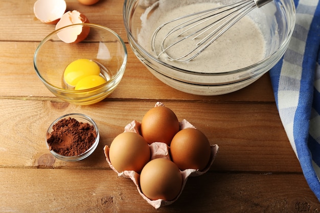 Creme de preparação com ovos em tigela de vidro na madeira