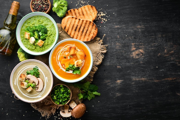 Creme de sopa de legumes colorido Comida dietética Em um fundo preto Vista superior Espaço para cópia grátis