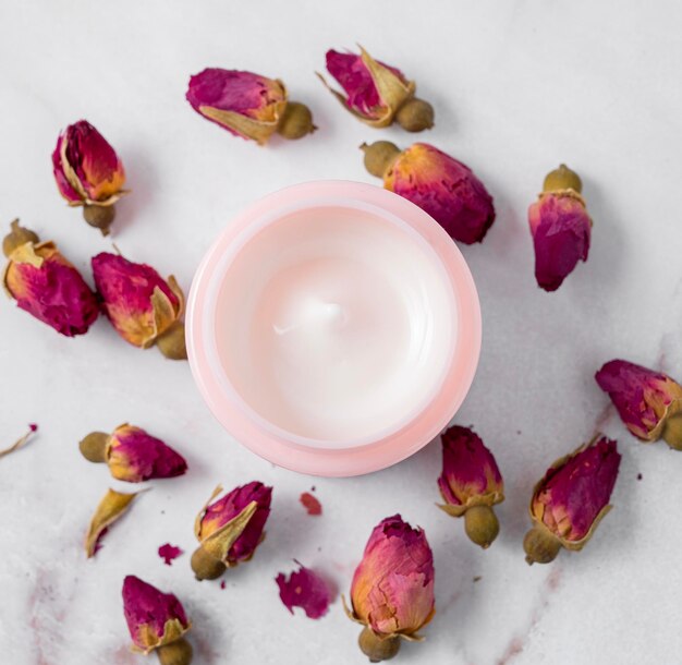 Creme facial e corporal sobre uma mesa de mármore fecha o conceito de cuidados cosméticos com rosa Saúde e beleza