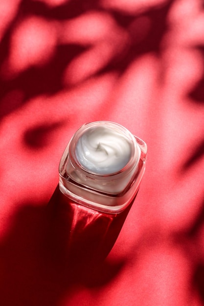 Creme hidratante para o rosto de beleza para pele sensível spa de luxo cosméticos e produtos de cuidados com a pele limpos naturais em fundo vermelho