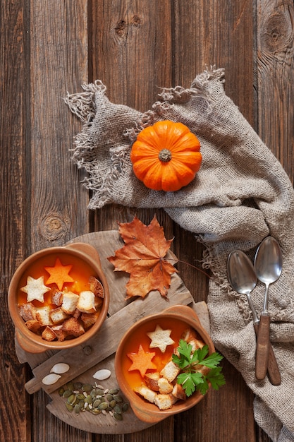 Foto creme-sopa caseiro tradicional da abóbora com sementes, biscoitos e pouca abóbora.