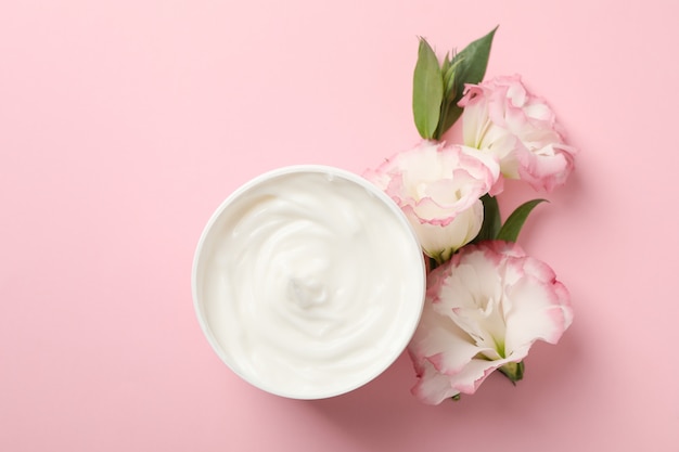 Creme und schöne blumen auf rosa hintergrund, platz für text