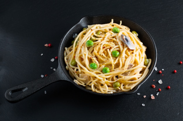 Cremefarbene Soße des selbst gemachten Spaghettis des Lebensmittelkonzeptes in der Gusseisenbratpfanne