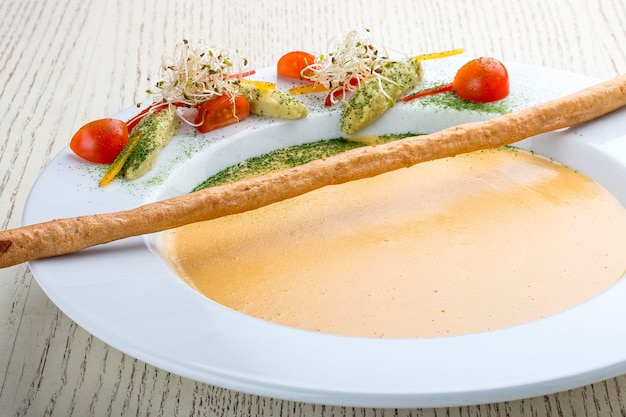 Foto cremesuppe mit lachs auf weißem hintergrund