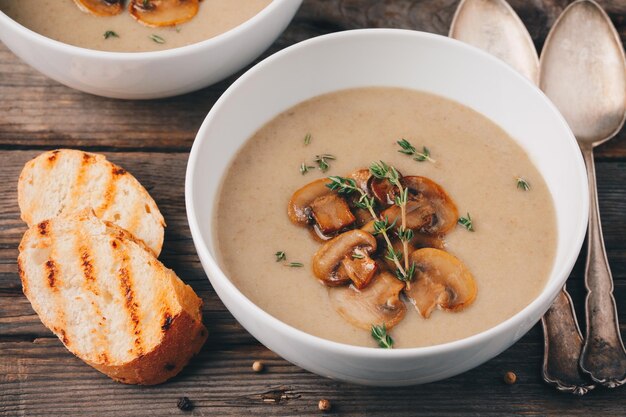 Cremesuppenpüree mit Pilzen mit Toastbrot auf Holzhintergrund