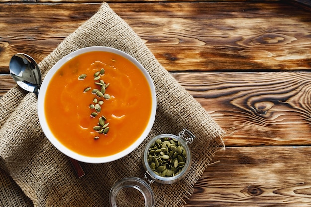 Cremige Kürbissuppe auf einem braunen Holztisch