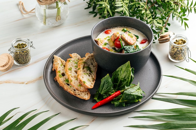 Cremige Suppe mit Lachs und französischem Baguette