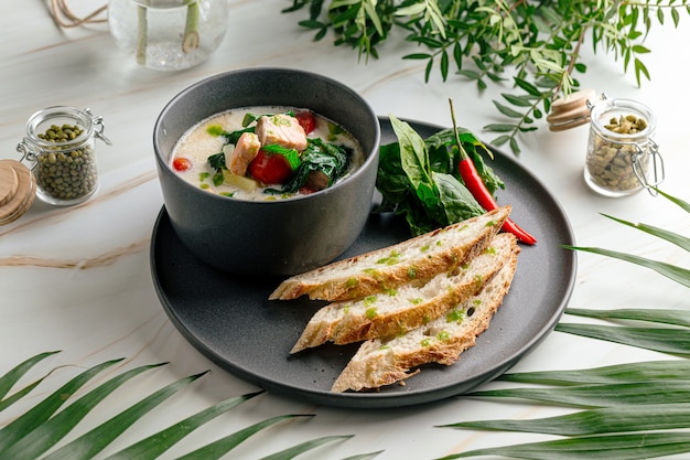 Cremige Suppe mit Lachs und französischem Baguette