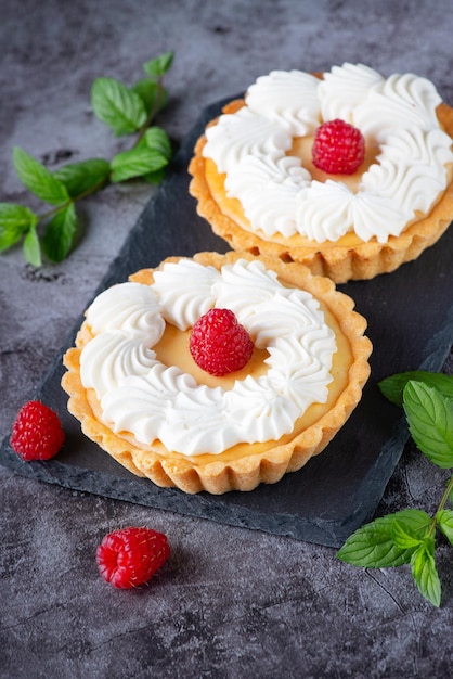 Cremiger Käsekuchenkuchen mit Himbeeren auf einem grauen Tisch