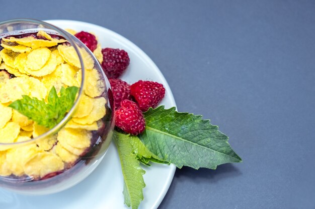 Cremiges Milchkaramell mit Himbeeren und Cornflakes. Nahaufnahme