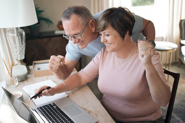 Creo que acabamos de recibir muy buenas noticias Foto de un esposo y una esposa maduros usando una computadora portátil juntos