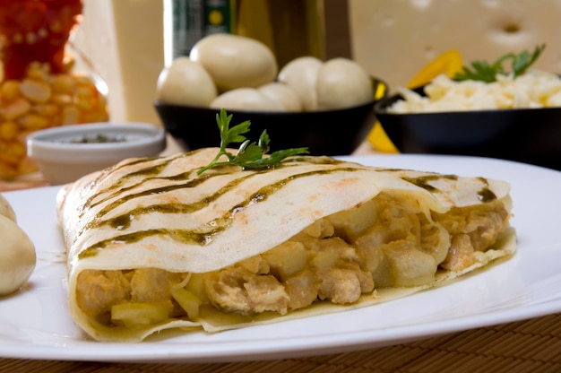 Crepe de estrogonofe de frango com ingredientes no fundo,