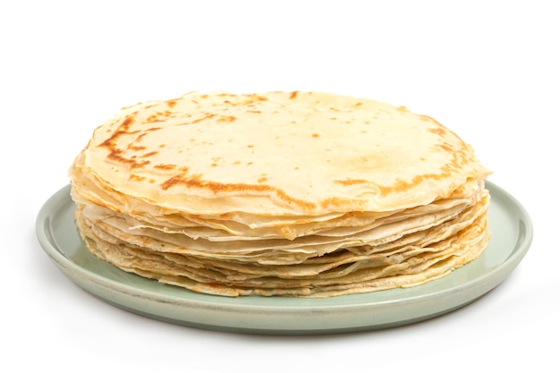 Crepe en plato aislado sobre fondo blanco. Montón de tortitas finas al estilo ruso para vacaciones Maslenitsa. Fondo de comida para el desayuno y el carnaval.