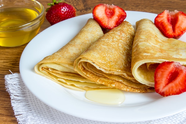 Crepes apiladas con sirope de fresa y miel.