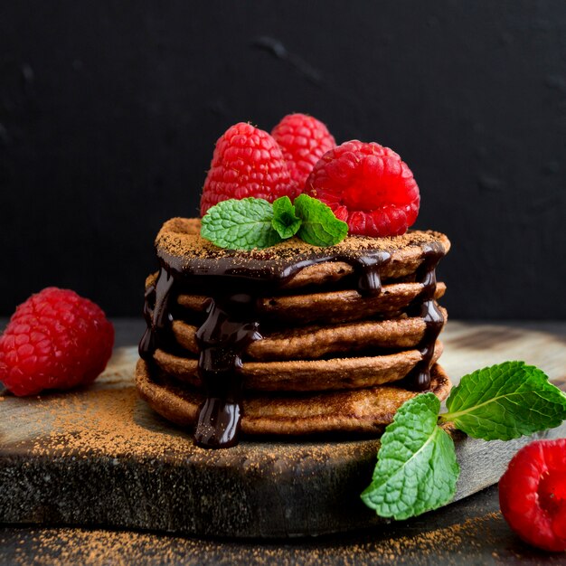 Crepes del chocolate con la frambuesa en un fondo oscuro.