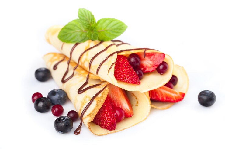 Foto crepes com bagas. crepe com cobertura de morango, framboesa, mirtilo e chocolate. panqueca