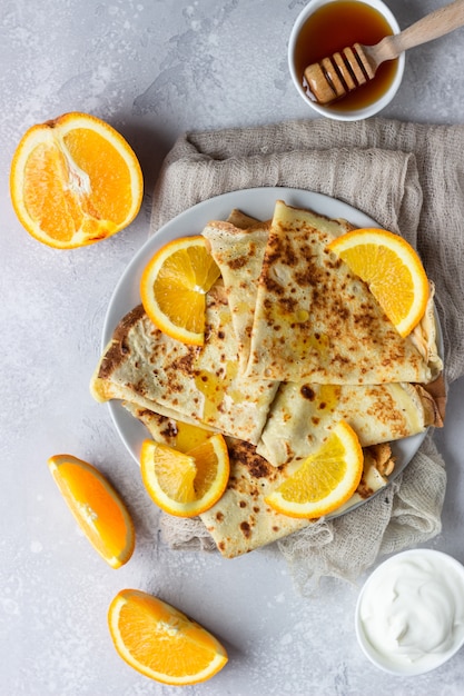 Crepes com laranja, mel e iogurte natural ou creme de leite. panquecas finas.