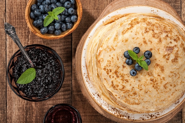 Crepes com mirtilos e geléia na mesa de madeira