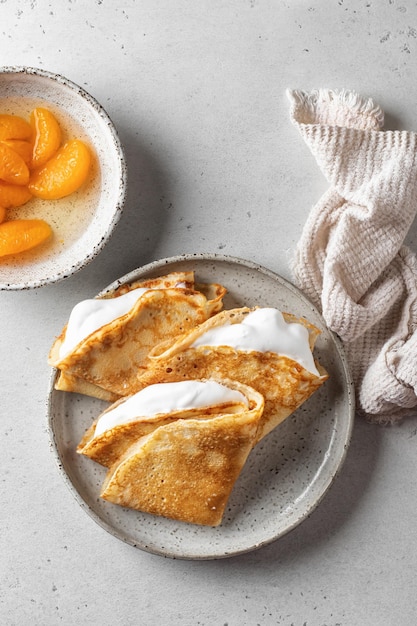 Crepes con crema de caramelo de mandarina fresca en el relleno sobre fondo blanco texturizado Maslenitsa o semana de panqueques concepto tradicional Vista superior espacio de texto plano